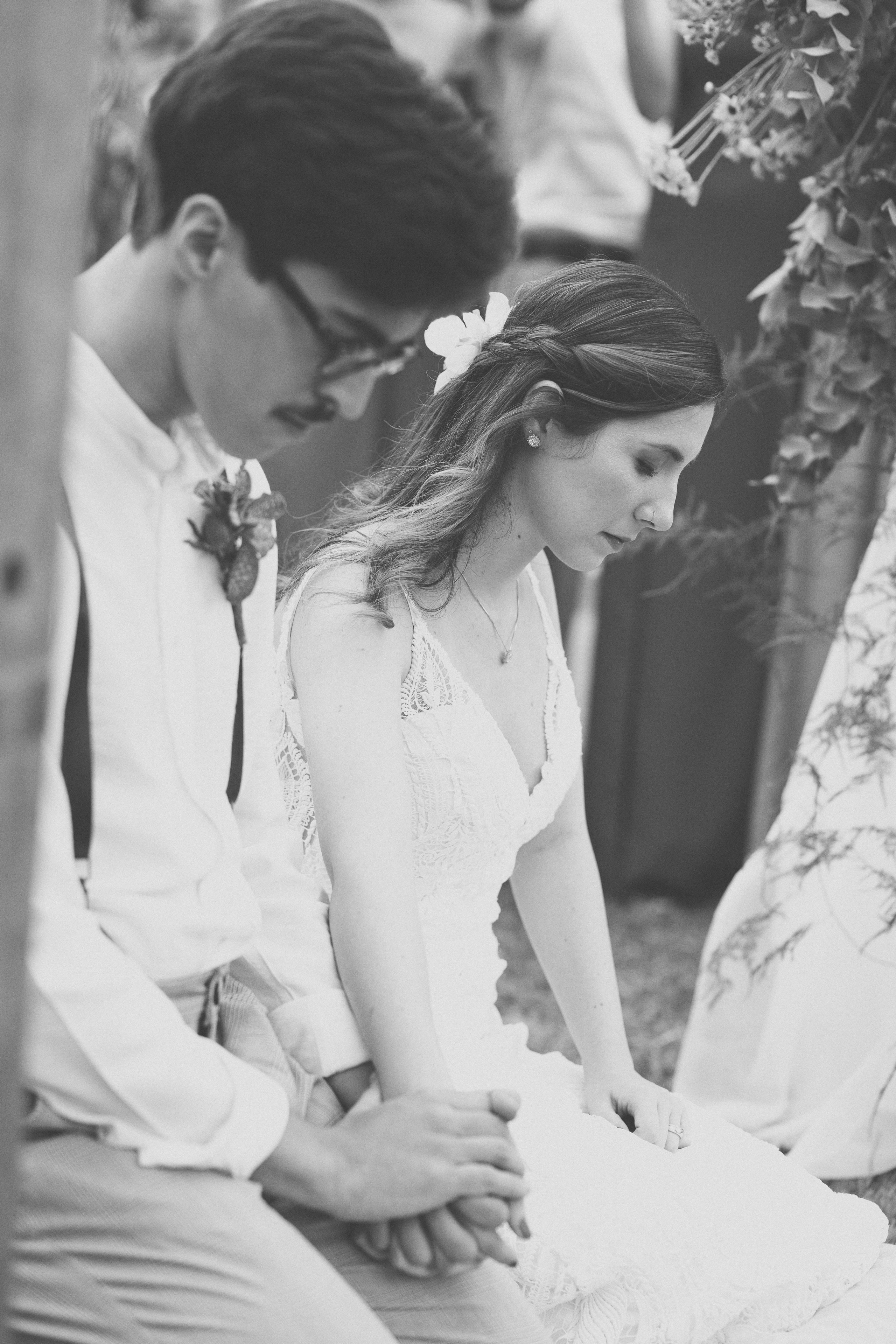 Casal em preto e branco assinando o livro de casamento durante cerimônia